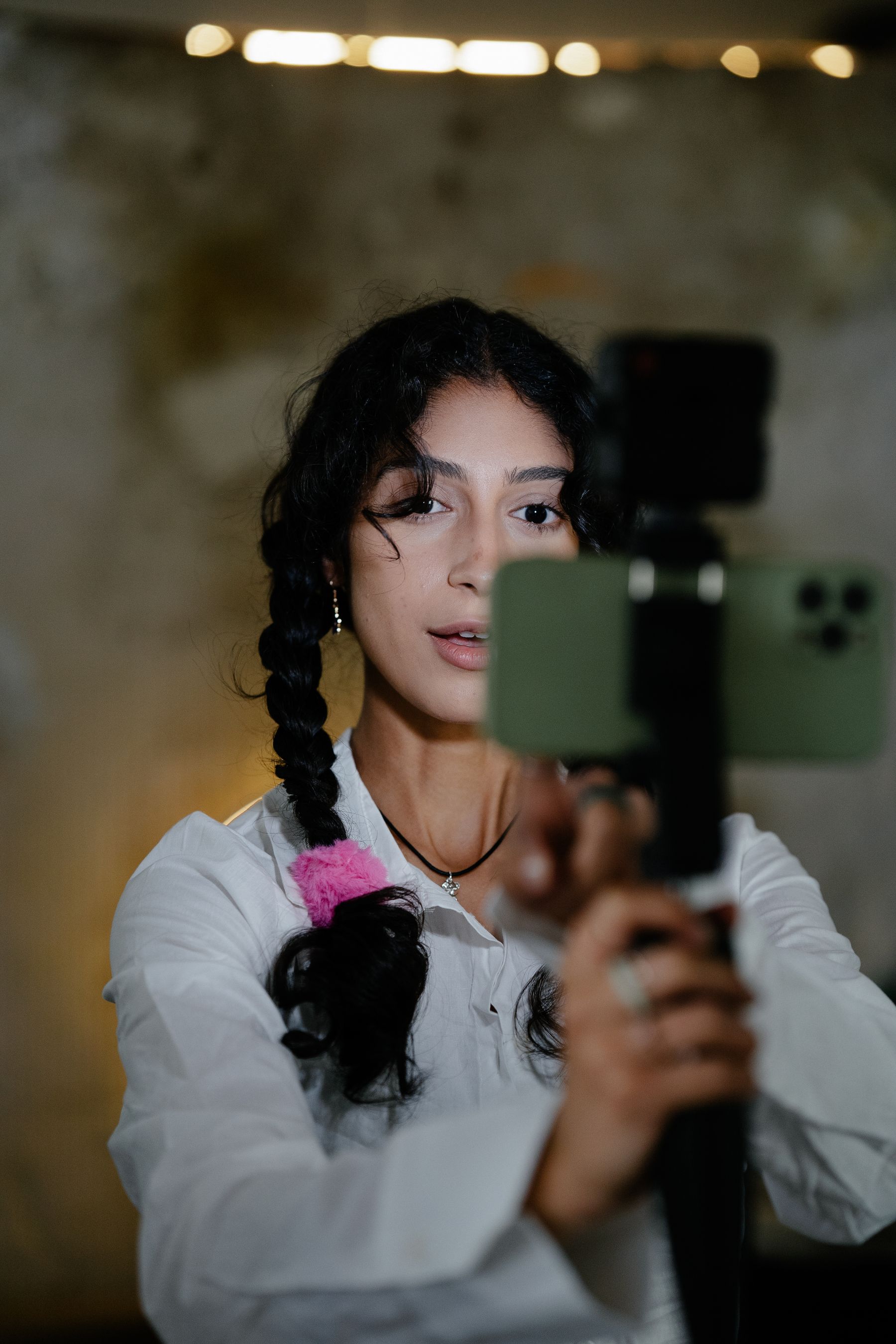 A creator records a video with a smartphone on a handheld stabilizer.